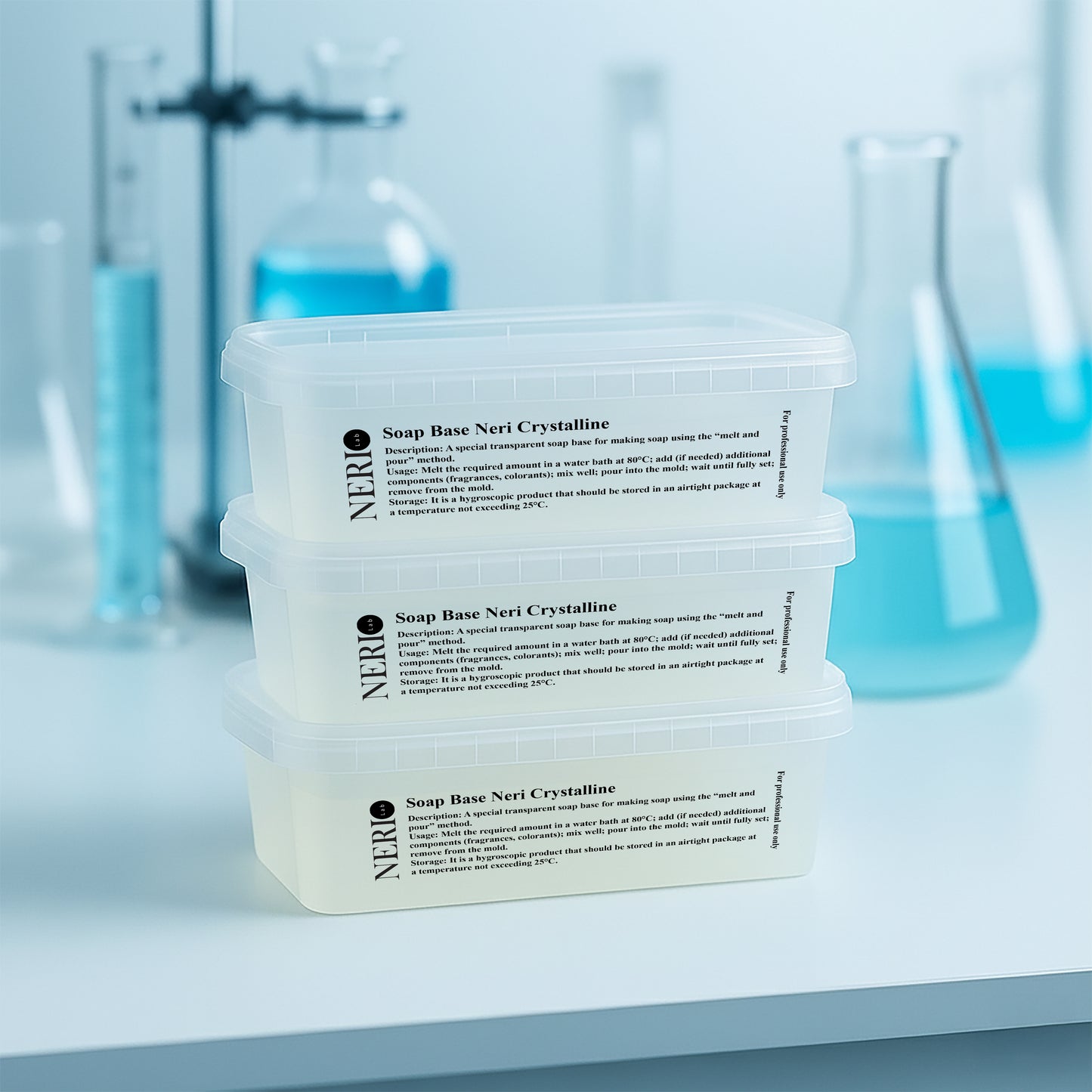 Three containers of NERIlab Soap Base Crystalline on a white surface with laboratory equipment in the background.